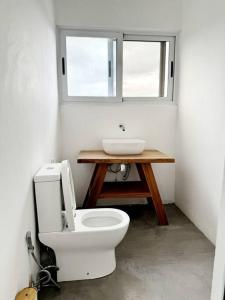 een badkamer met een wit toilet en een wastafel bij Escape with a view of the dunes in Santaca