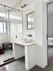 een witte badkamer met een wastafel en een spiegel bij Escape with a view of the dunes in Santaca