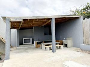 een paviljoen met een tafel en een tv op een patio bij Escape with a view of the dunes in Santaca