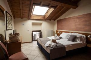 a bedroom with a large bed with a skylight at Appartamenti La Grotta in Bardolino