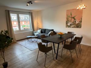 uma sala de estar com uma mesa e um sofá em Business Apartment Kranich: 3 Zimmer, Top Infrastrukturlage HH Langenhorn, Nähe Airport em Hamburgo