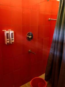 Baño de azulejos rojos con aseo en una cabina en Nirvana Guest House, en Guwahati