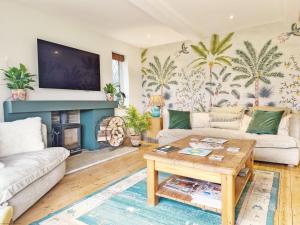 a living room with a couch and a fireplace at Broomy Cottage in Pulborough