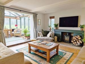a living room with a fireplace and a tv at Broomy Cottage in Pulborough