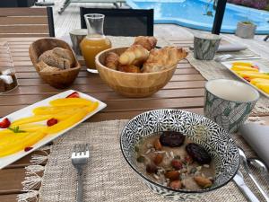 een tafel met een kom eten en een kom brood bij La Grange du Coulin in Onesse-et-Laharie
