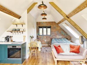 een keuken en een woonkamer met een bed in een loft bij Broomy Cottage in Pulborough
