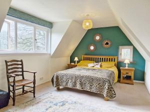 een slaapkamer met een bed en een groene muur bij Broomy Cottage in Pulborough