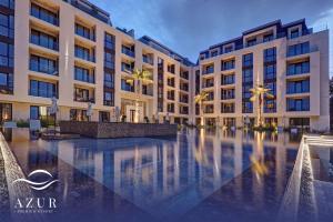 une cour d'hôtel avec des palmiers et des bâtiments dans l'établissement Azur Premium Resort, à Saints Constantine et Helena