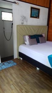 a bedroom with a large bed with white sheets at Naca Homestay in Manado