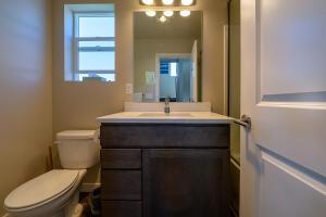 uma casa de banho com um lavatório, um WC e um espelho. em Seattle Urban Village -Private Room- Vashon - Roof Top View Deck em Seattle