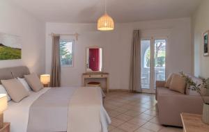 ein weißes Schlafzimmer mit einem Bett und einer Couch in der Unterkunft Asteras Paradise in Naoussa