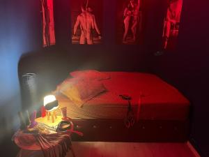 a bedroom with a red bed and a table with a lamp at BDSM Apartament Constanta Mamaia - Adults only in Constanţa