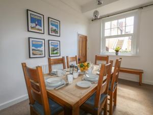 a dining room with a wooden table and chairs at Blue Yonder in Weymouth