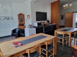 a living room with a table and a television at Spói Guesthouse in Hvolsvöllur