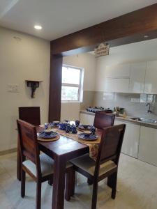 a dining room table with chairs and a kitchen at Vrunda 2BHK spacious and cozy Homestay in Vrindāvan
