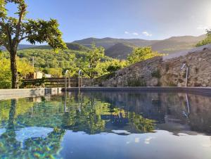 a swimming pool with a view of the mountains at Cal Gat in Les Planes d'Hostoles