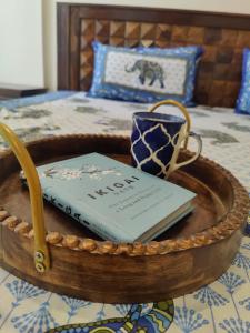 a tray with a book and a cup on a bed at Vrunda 2BHK spacious and cozy Homestay in Vrindāvan