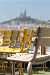 uma fila de cadeiras sentadas numa varanda em Hôtel Hermès em Marselha
