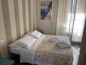 a bedroom with a bed with two towels on it at Corte Meraviglia - Relais in Lucca