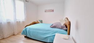 Dormitorio blanco con cama y mesa con lámpara en Les Glycines - Maison avec bel extérieur 