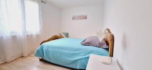 a white bedroom with a bed and a table with a lamp at Les Glycines - Maison avec bel extérieur in Bonneil