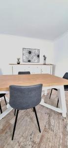 una mesa de madera con una silla en una habitación en Les Glycines - Maison avec bel extérieur 