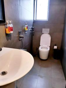 a bathroom with a white sink and a toilet at Hotel Samrat, Mumbai in Mumbai