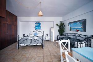 um quarto com 2 camas de ferro e uma mesa em Lappa Apartments em Argyroupolis