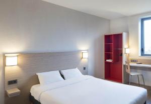 1 dormitorio con 1 cama blanca grande y armario rojo en B&B HOTEL Laval Ouest, en Laval