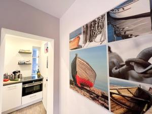 a kitchen with pictures of boats on the wall at gina stay - Gemütliches Apartment direkt in Scharbeutz in Scharbeutz +12 photos