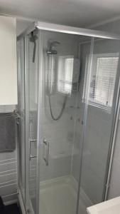 a shower with a glass door in a bathroom at 25. Valencia in Selsey