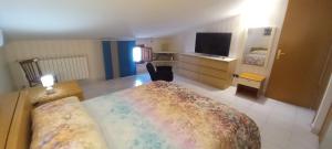Un dormitorio con una cama grande y un televisor. en Basilicò, en Caltagirone