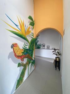 a painting of a bird on a wall in a hallway at HOTEL LAS PALMAS in La Virginia