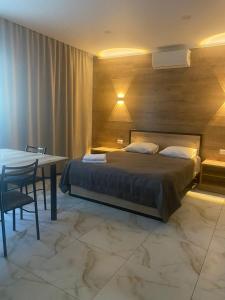 una camera da letto con un letto, un tavolo e una scrivania di Гостевой дом Шумкар Азия Guest House Shumkar Asia a Bishkek