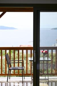 a chair and a table on a balcony at Makis Sea View Studios in Skiathos Town