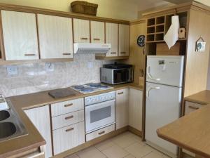 a kitchen with a white stove and a refrigerator at Sea view cottage in Great Brak River