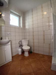 a bathroom with a toilet and a sink and a window at Domimat-Lila in Dębki