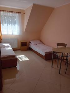 a small room with two beds and a table at Domimat-Lila in Dębki