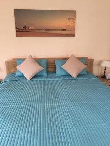 1 cama con edredón y almohadas azules en Haus Nicolai FeWo 8, en Baabe