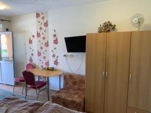 a living room with a large wooden cabinet and a table at Studio Florida in Štúrovo