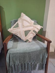 a pillow with a cross on it sitting on a chair at Fraai Maraai Self Catering Apartments in Groblersdal