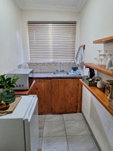 a kitchen with a sink and a microwave at Fraai Maraai Self Catering Apartments in Groblersdal