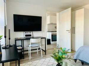a living room with a desk with a television on the wall at Klein aber fein in Meerbusch
