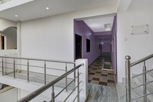 un pasillo con escaleras y paredes de color púrpura y blanco en OYO Flagship 24 Stays, en Chinhat
