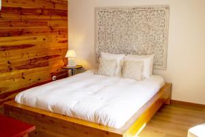 um quarto com uma cama e uma parede de madeira em Quinta da Relva - Soulful House em Mafra