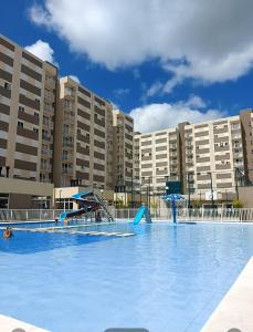 a large swimming pool in front of a large building at Apto ao lado do Parque UNA in Pelotas