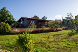 uma pequena casa num quintal com um relvado verde em Quinta da Relva - Soulful House em Mafra