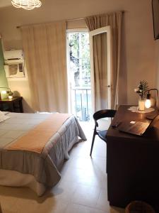 sypialnia z łóżkiem, biurkiem i oknem w obiekcie Hotel Namaste w mieście Mendoza