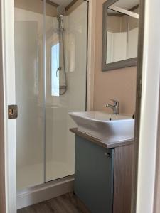 ein Badezimmer mit Waschbecken und Dusche in der Unterkunft Regal Beachside pitch 22 Creek Caravan Park in Ringstead + 46 Fotos