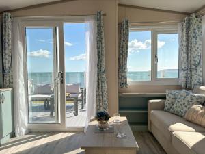 ein Wohnzimmer mit Couch und großem Fenster in der Unterkunft Regal Beachside pitch 22 Creek Caravan Park in Ringstead